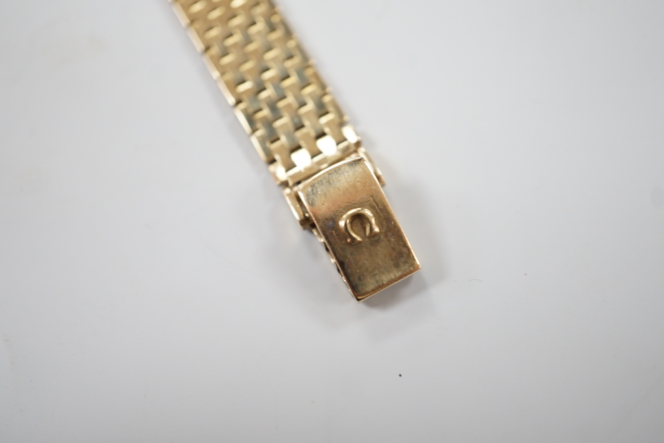 A lady's 9ct gold Omega quartz wrist watch, on a 9ct gold Omega bracelet, overall 17.3cm, gross weight 29 grams, with Omega box and booklet.